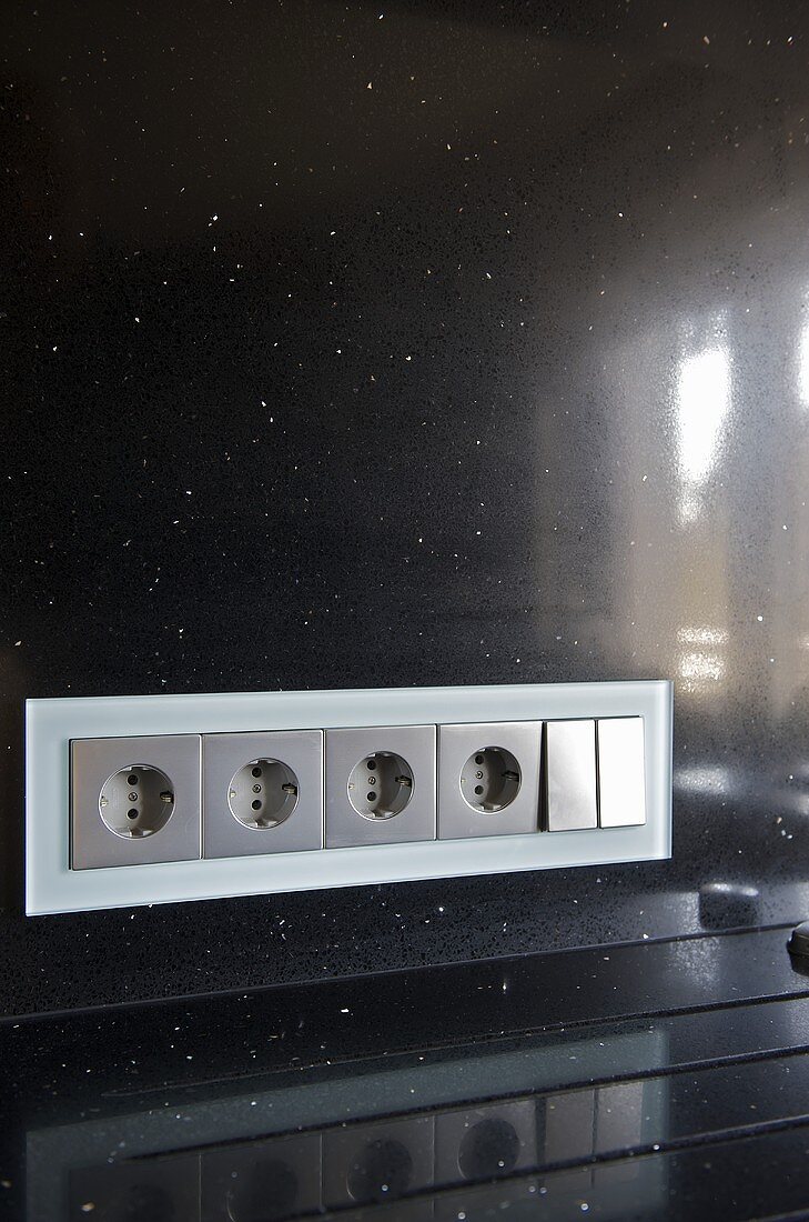 Steckdosenleiste in schwarzer Rückwand einer modernen Küche