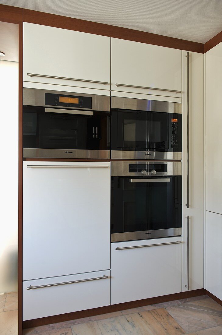 Moderne Küche mit weißen Schrankeinheiten und integrierten Einbaugeräten