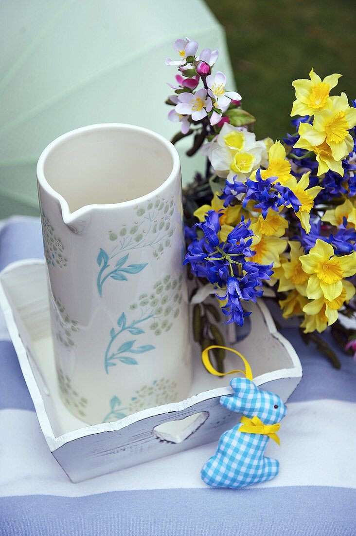Posy of spring flowers next to jug