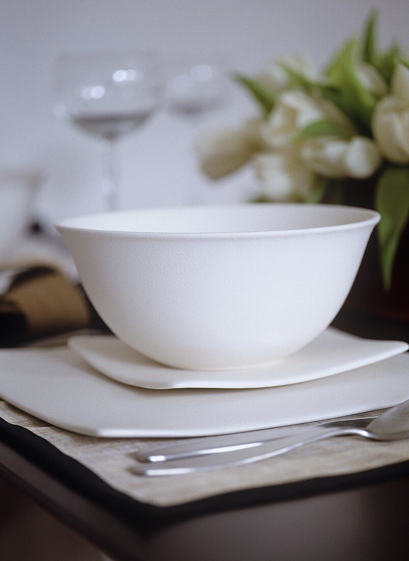 Gedeck - weiße Keramikschüssel auf quadratischen Tellern