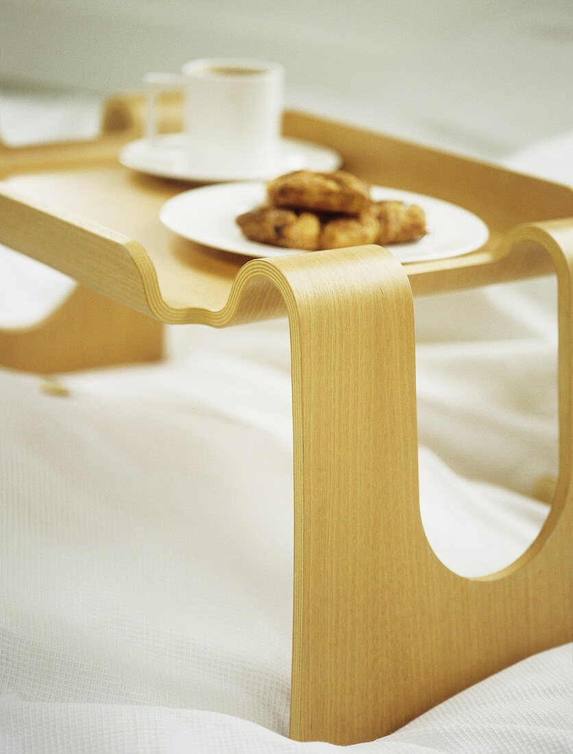 Frühstückstablett aus geschwungenem Holz auf Bett
