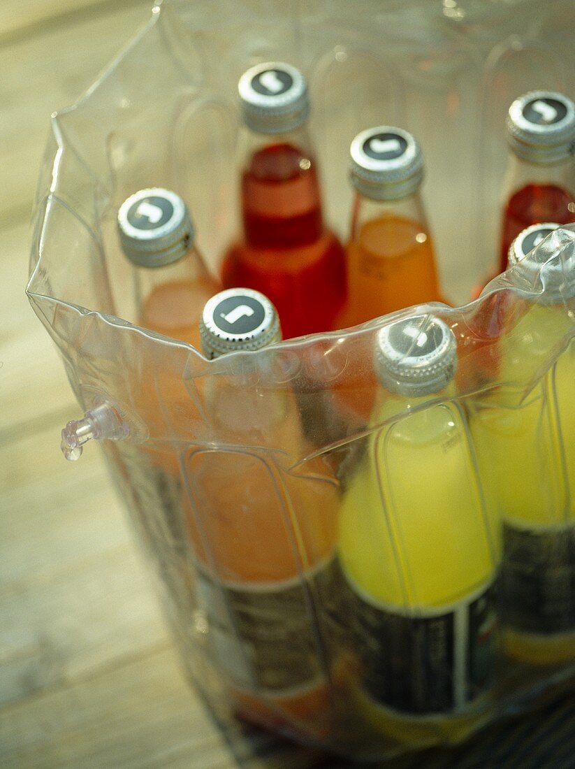 Saftflaschen in transparentem Getränkekühler aus Plastik