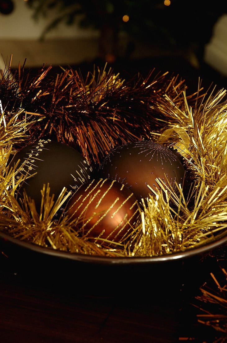 Christmas ball ornaments with gold tinsel in a bowl