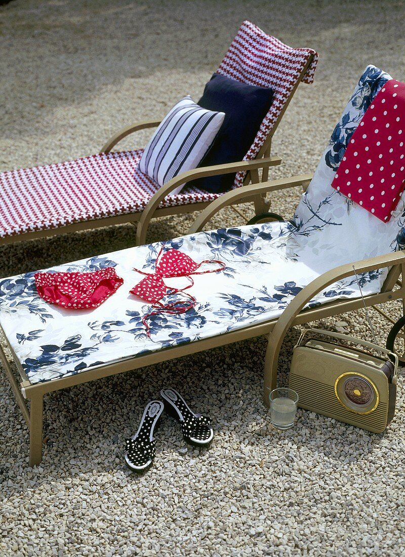 Sonnenpause - Liegestühle mit bunten Polstern auf Kiesboden