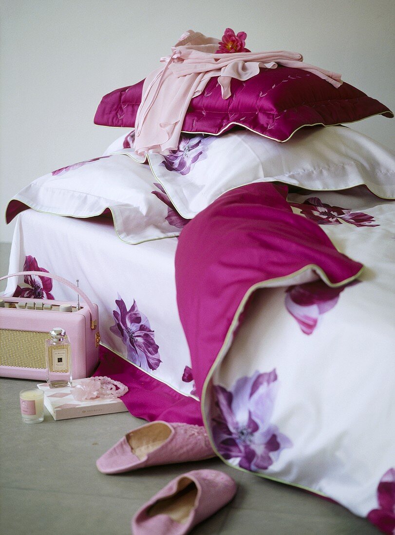 A detail of a girlÕs bedroom, single bed with pink floral cover, retro style radio, slippers,