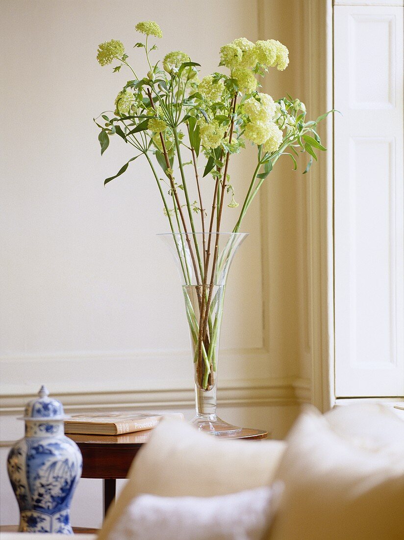 Sitting room with white panelled walls, antique china vase and flower arrangement.