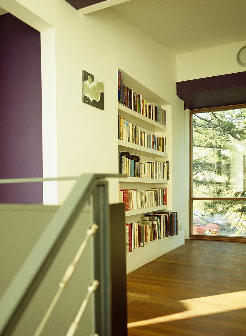 Flur mit eingebautem Bücherregal und Fensterfront