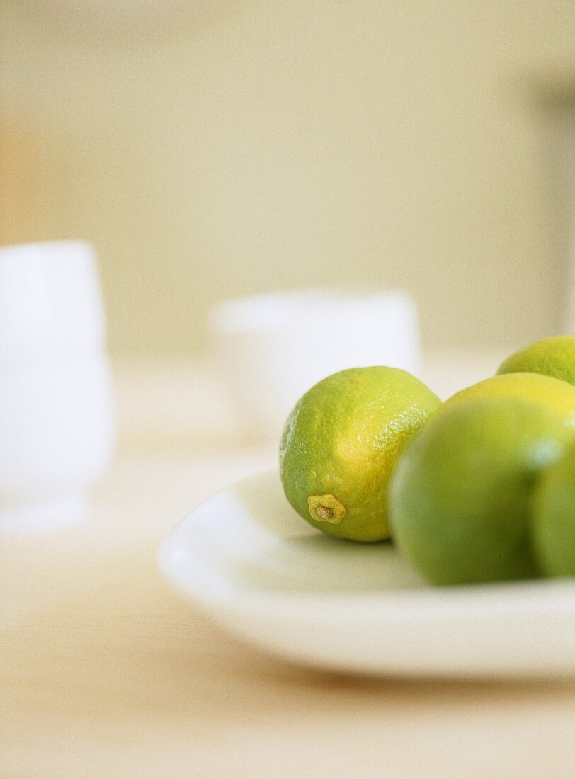 Close up of limes on white plate.