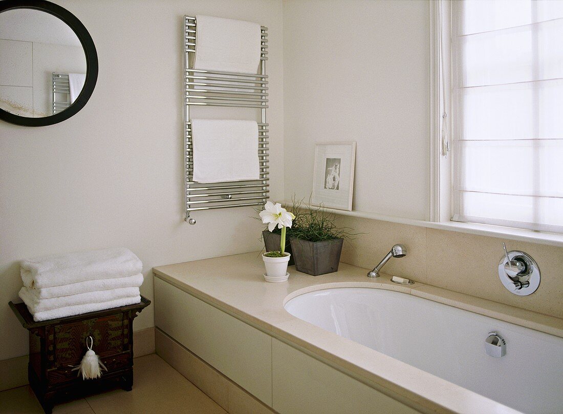 Modernes Bad mit Marmorverkleidung an Badewanne und Chrom Handtuchwärmer