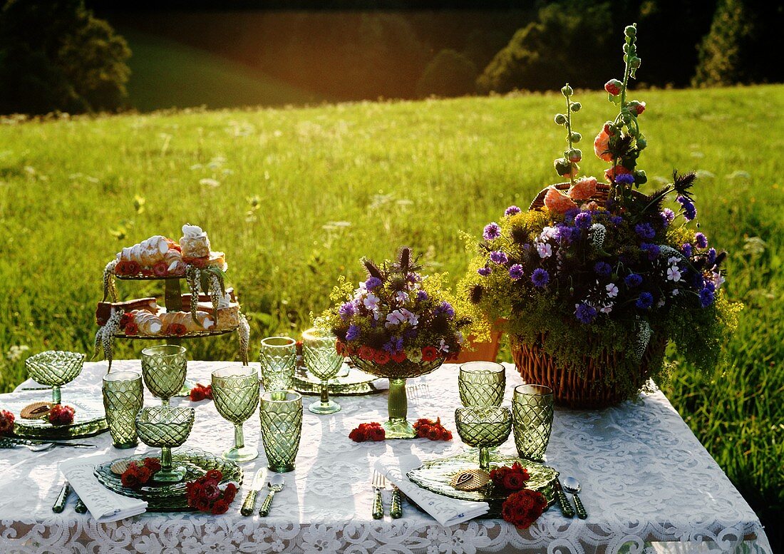 Abendliche Tafel mit Blumenschmuck und Gebäck