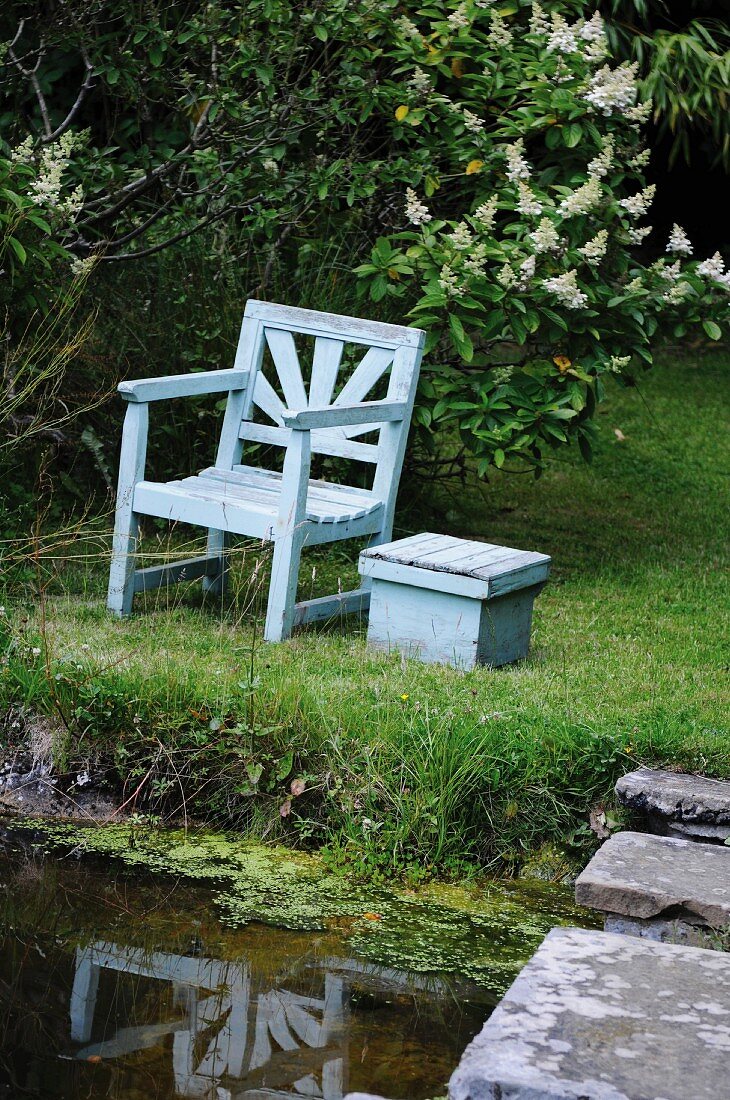 Holzstuhl und Tisch am Gartenteich