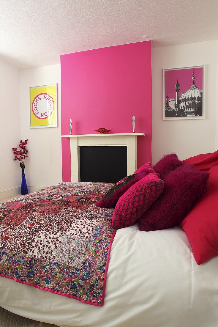 Ein Doppelbett in einem Schlafzimmer mit weissen und pinkfarbenen Wänden