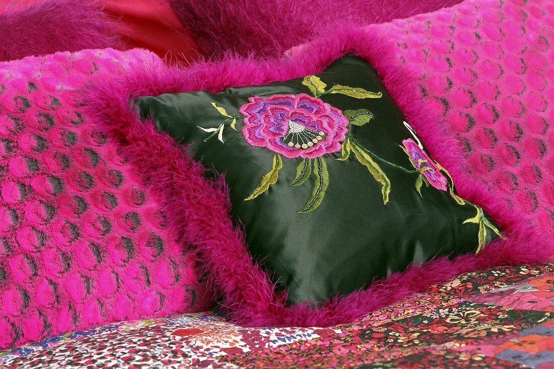 Pinkfarbene Dekokissen auf einem Bett