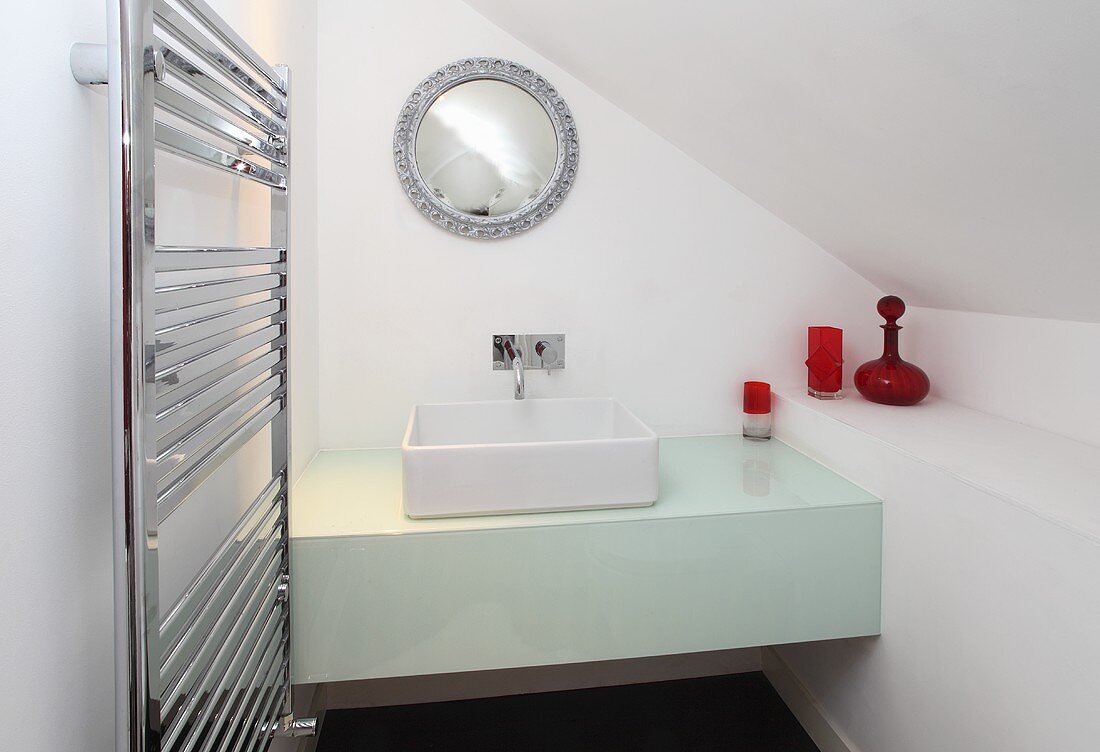 A square wash basin on a washstand in a white bathroom in an attic