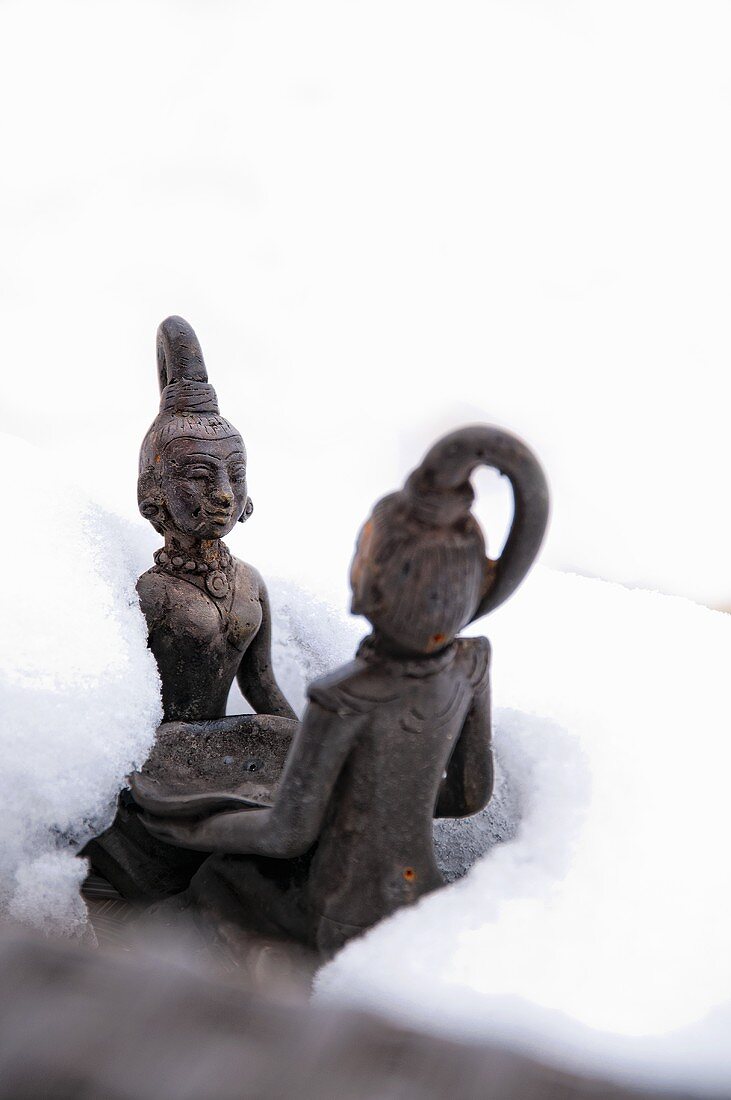 Asiatische Gartenfiguren im Schnee