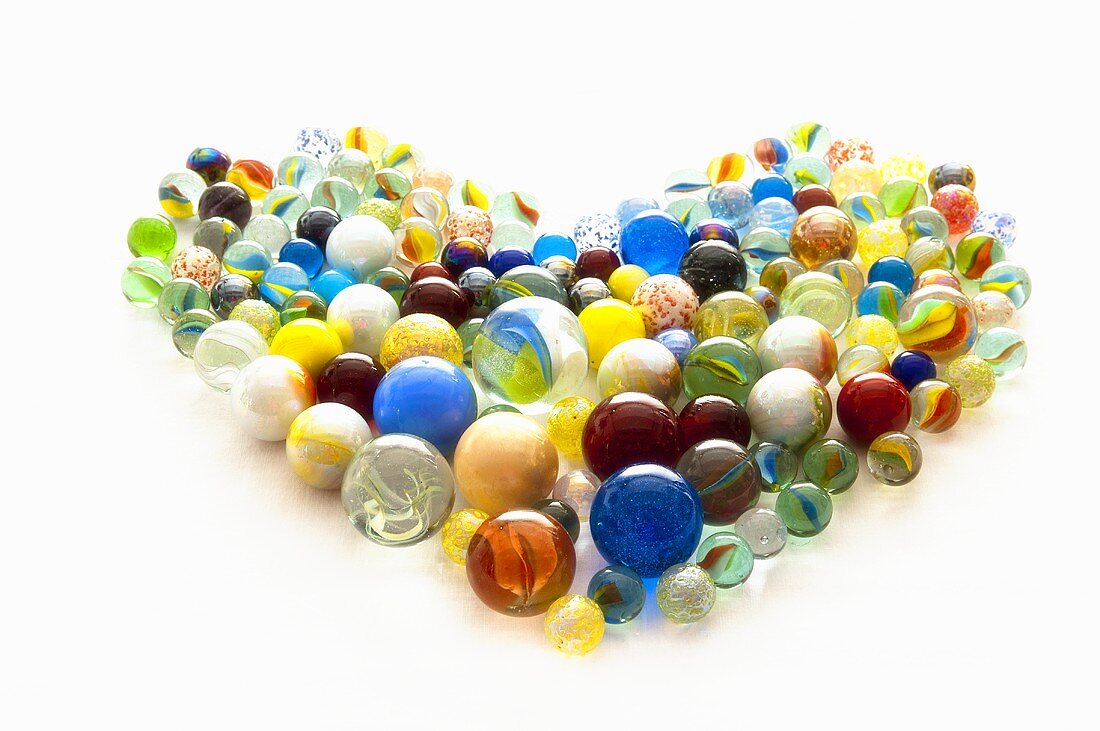 Colourful glass marbles arranged in a heart shape