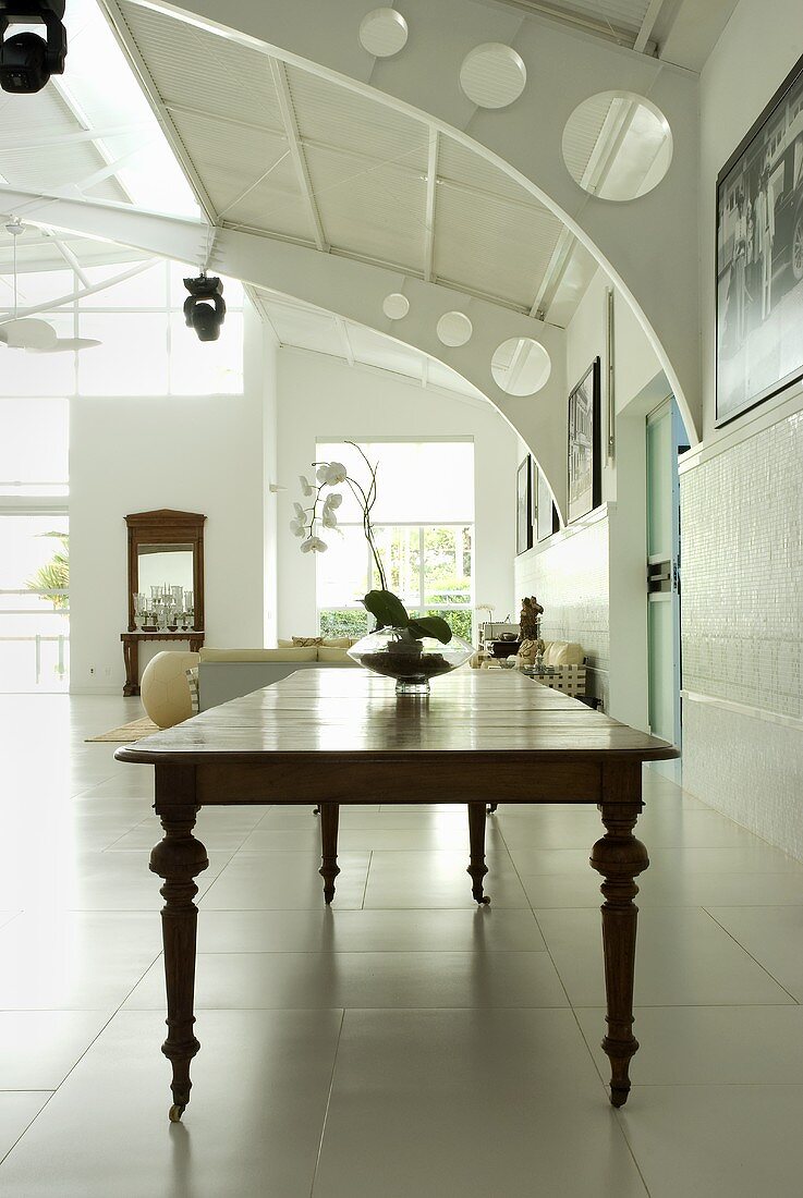 A long wooden table from the 18th century in a room with metal construction elements
