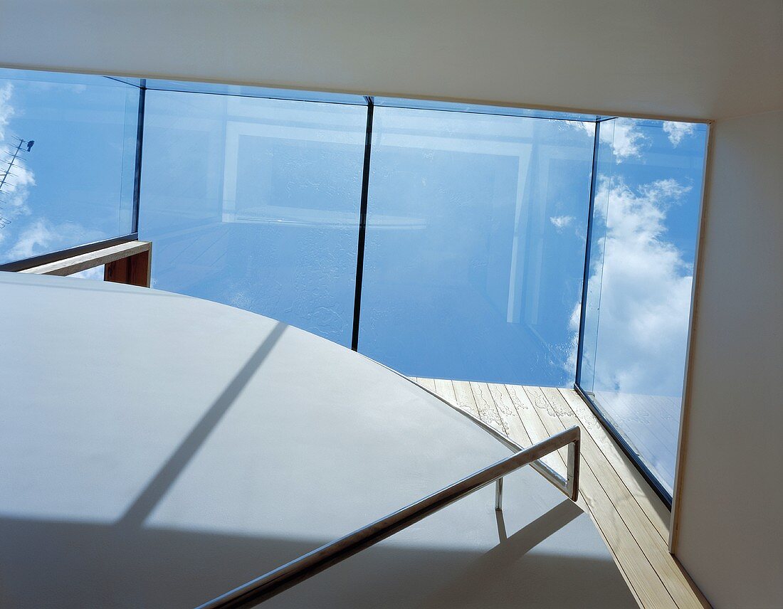 View of the sky through the glass roof of a staircase