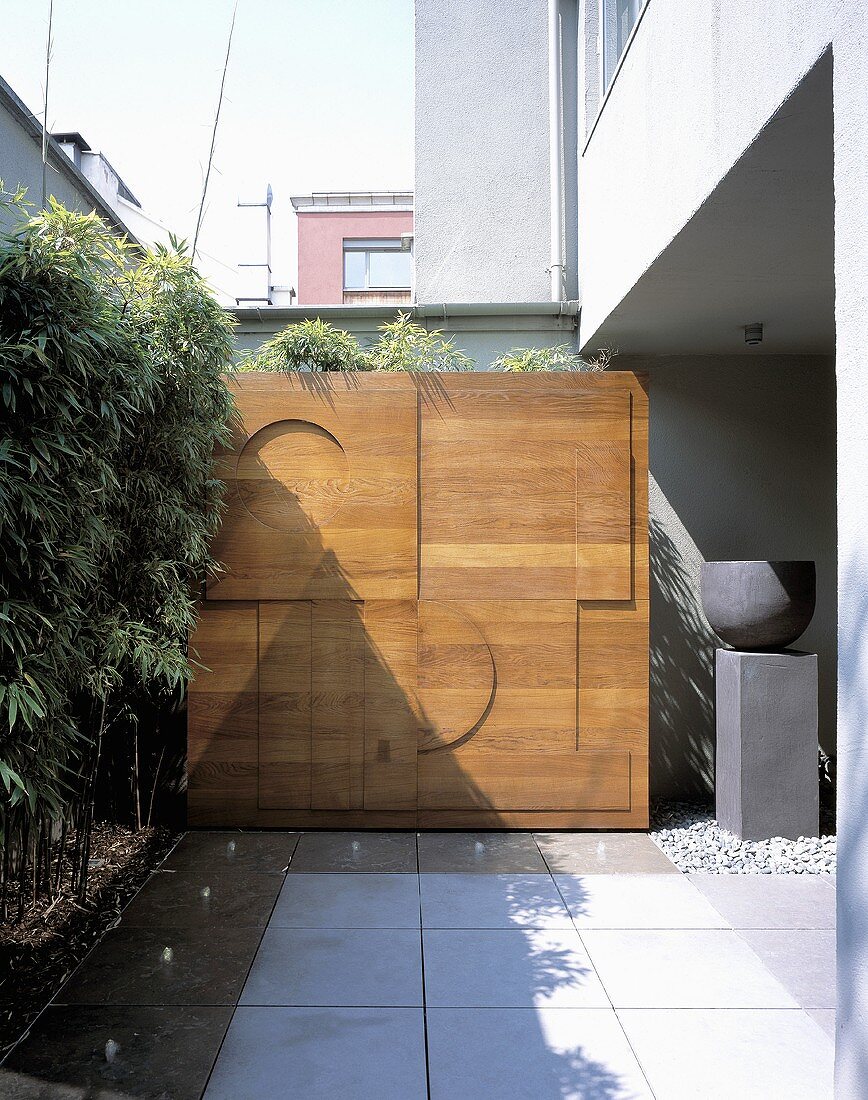 Holztrennwand mit modernen Reliefmotiven auf Wohnhausterrasse