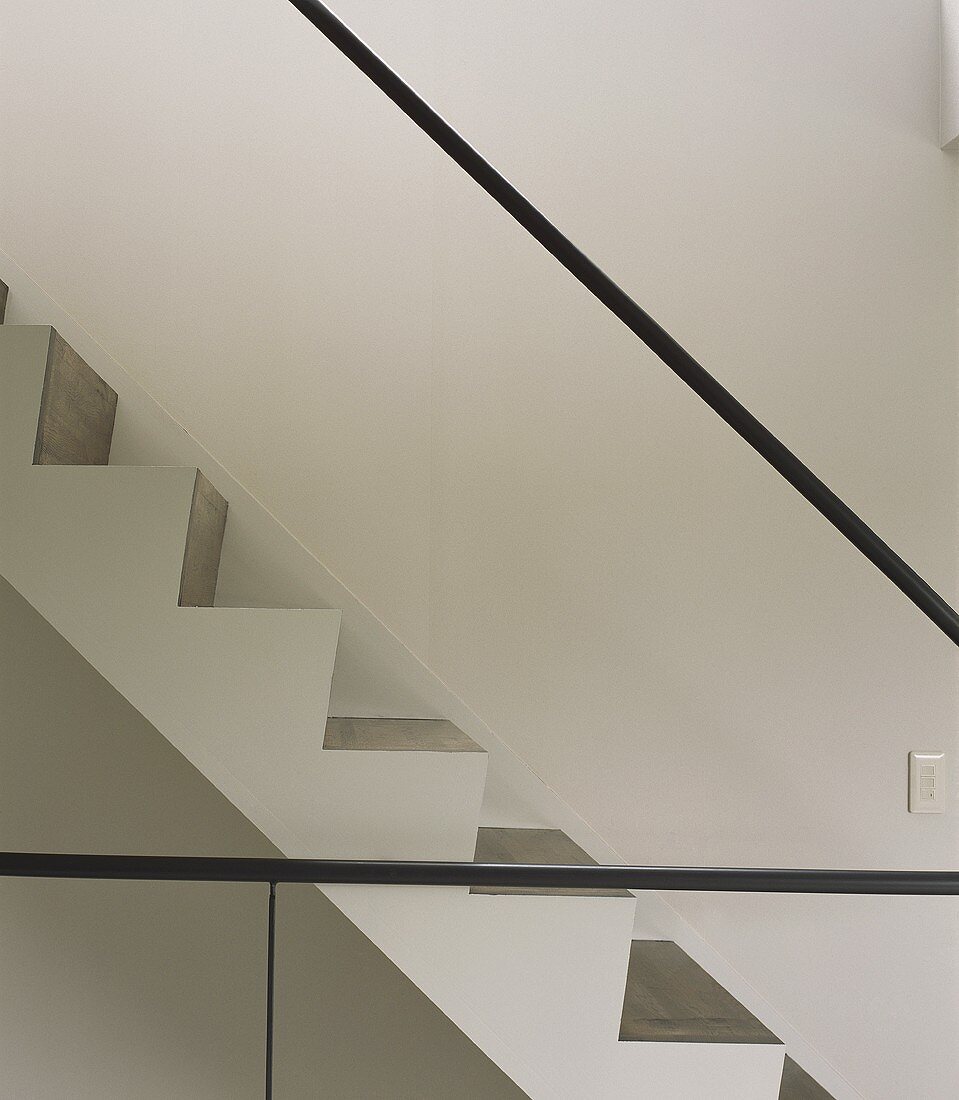 Section of a stairway with minimalist stainless steel handrail