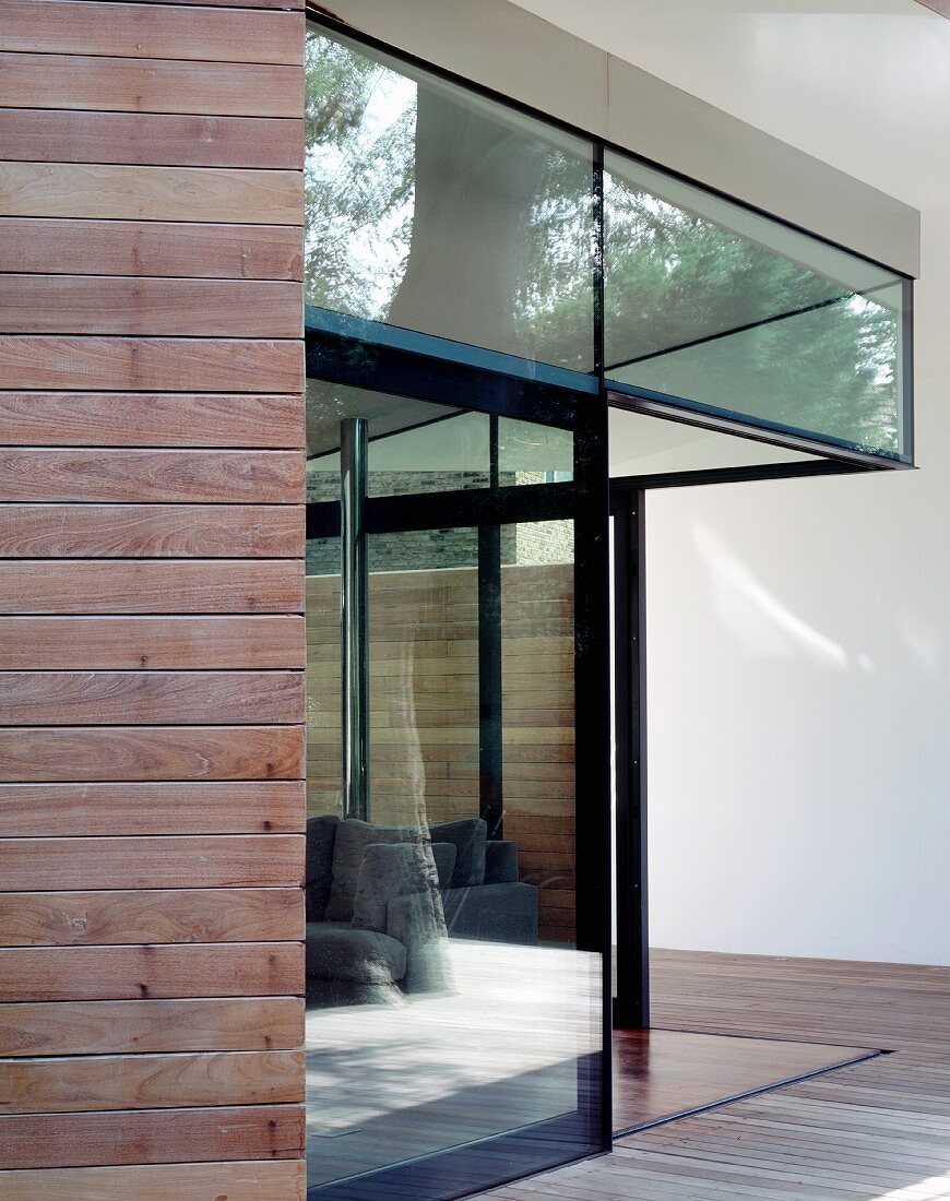 Corner of a house with a glass facade and open patio door