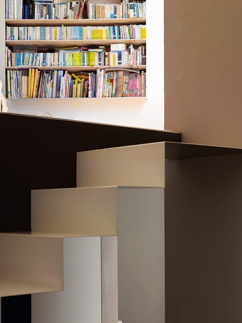 Folded metal staircase and view of bookshelves