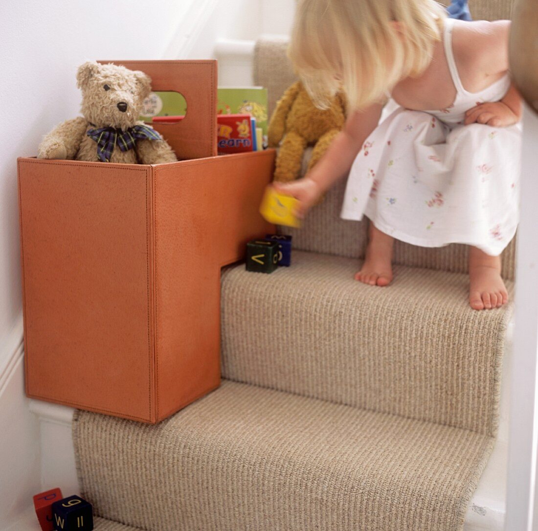 Kleines Mädchen spielt auf der Treppe