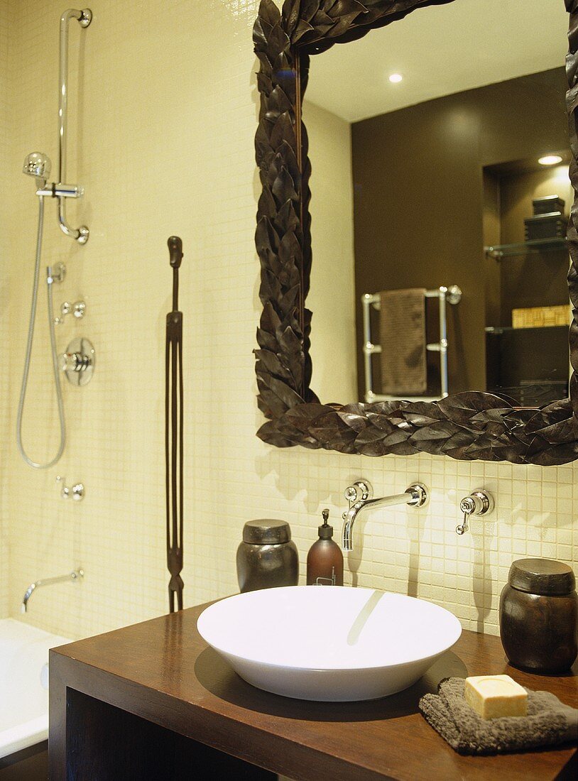 Badezimmer mit modernem Waschtisch und weisser Schüssel vor Spiegel