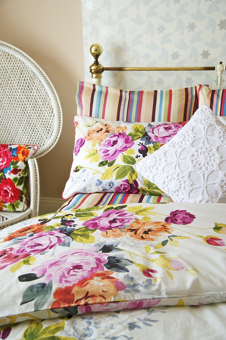 Messingbett mit Blumenmuster auf Bettwäsche und Kissen