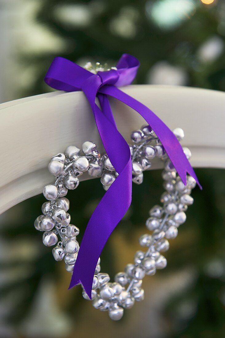 A heart-shaped pearl necklace with a purple ribbon