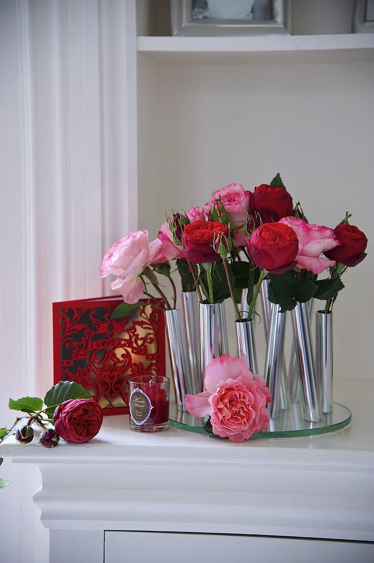Roses in individual cylindrical metal vases