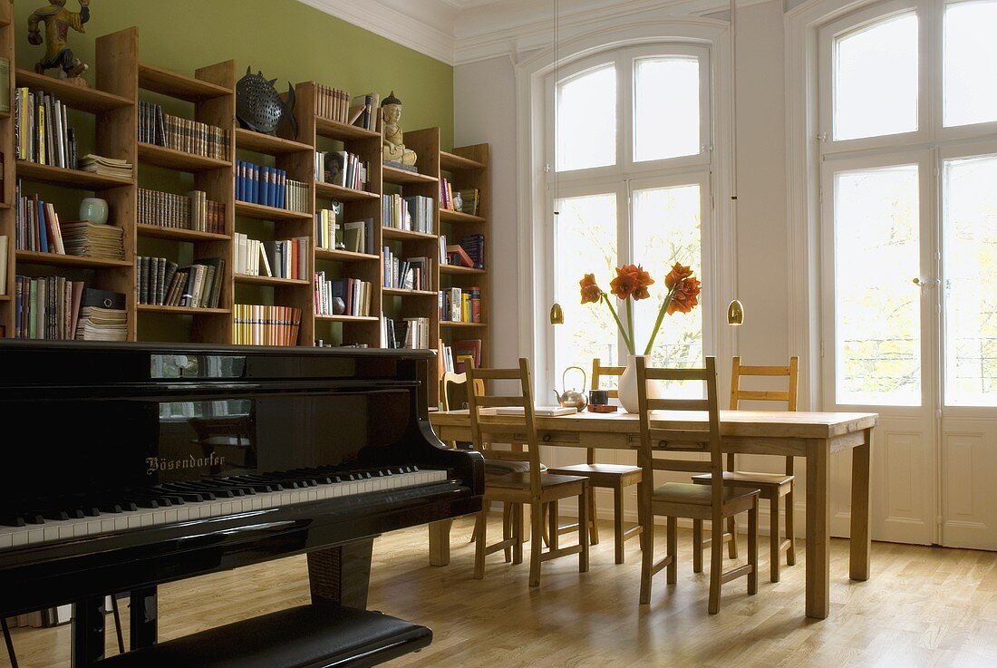 Klavier im Wohn- Essraum mit Holztisch vor Fenster und Balkontür