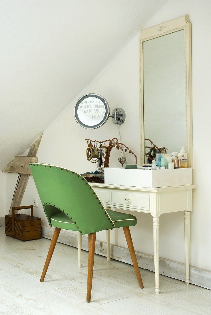 Grüner Stuhl im Fiftiesstil vor Schminktisch mit Spiegel