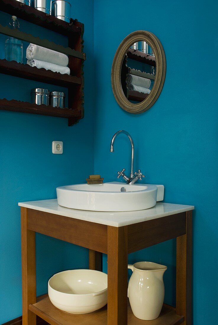 Corner of a room painted blue with a wash stand and washbasin