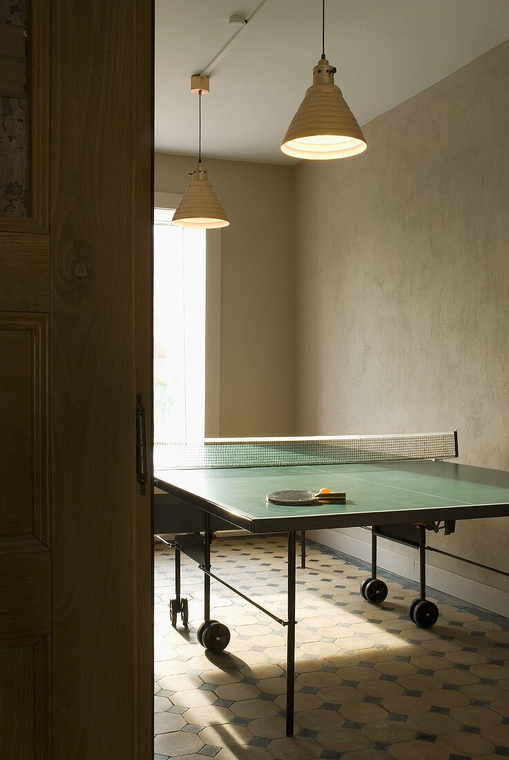 A pendent lamp above a table tennis table