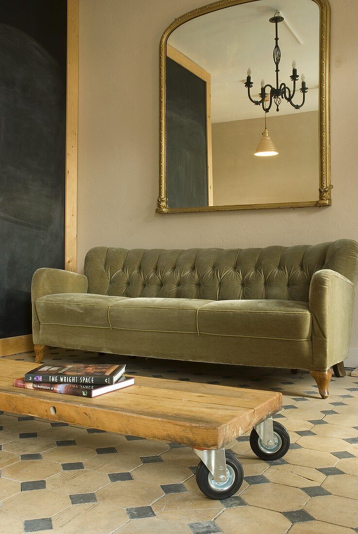 A grey sofa and a wheeled coffee table with a simple wooden top