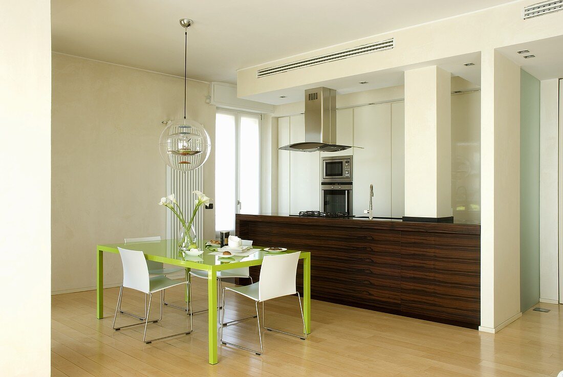 Essplatz mit grünem Tisch in offener Küche mit Küchenblock aus Holz