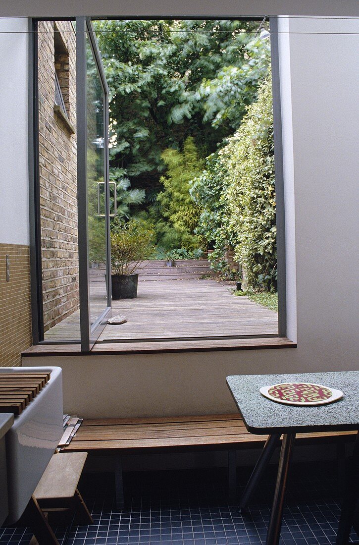Kitchen with open terrace door looking onto a garden