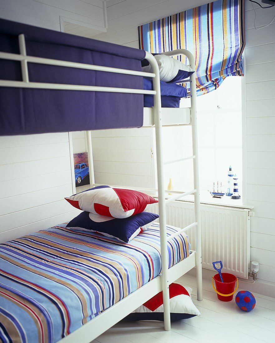 A white metal bunk bed in a children's bedroom