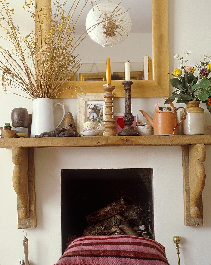 A rustic wooden mantelpiece with a mirror above it