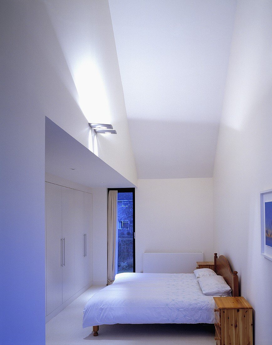 A modern bedroom with wall lighting and a double bed