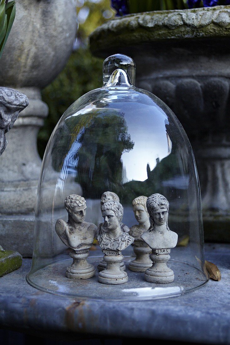Schachfiguren aus Stein unter Glashaube im Garten