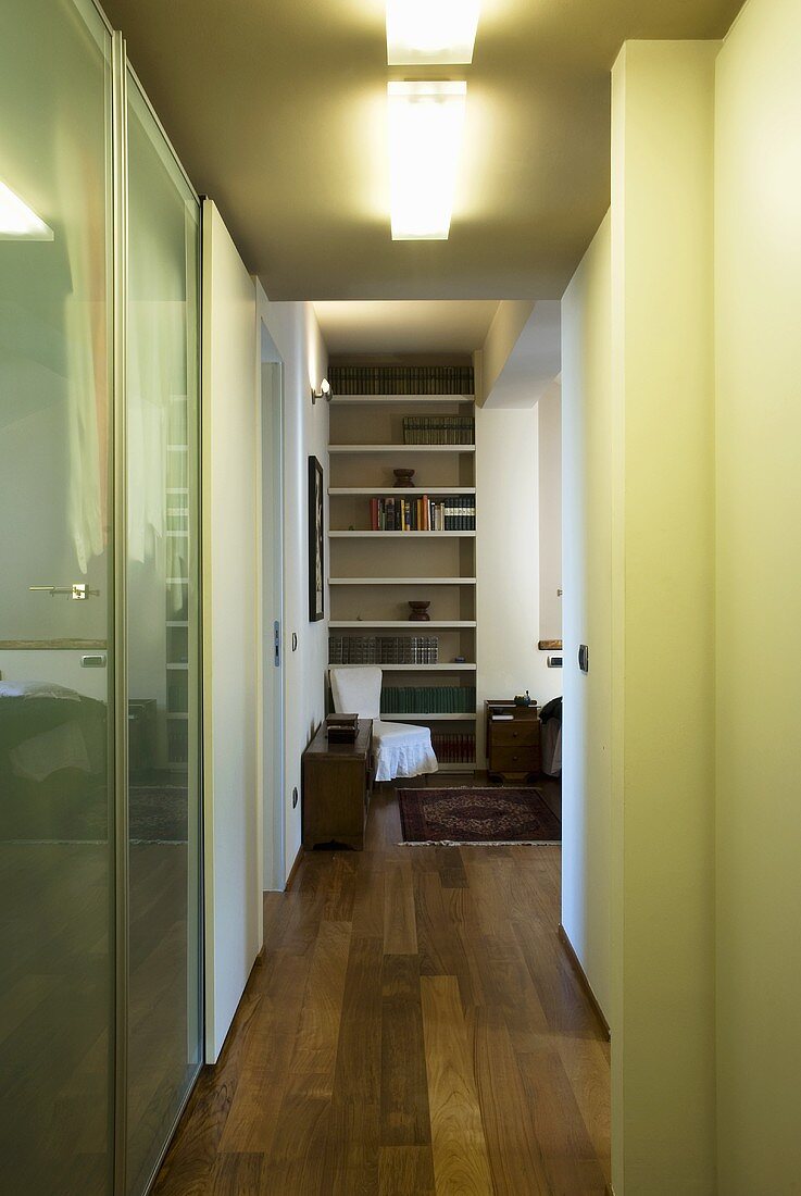 A hallway with a view of a built-in shelf