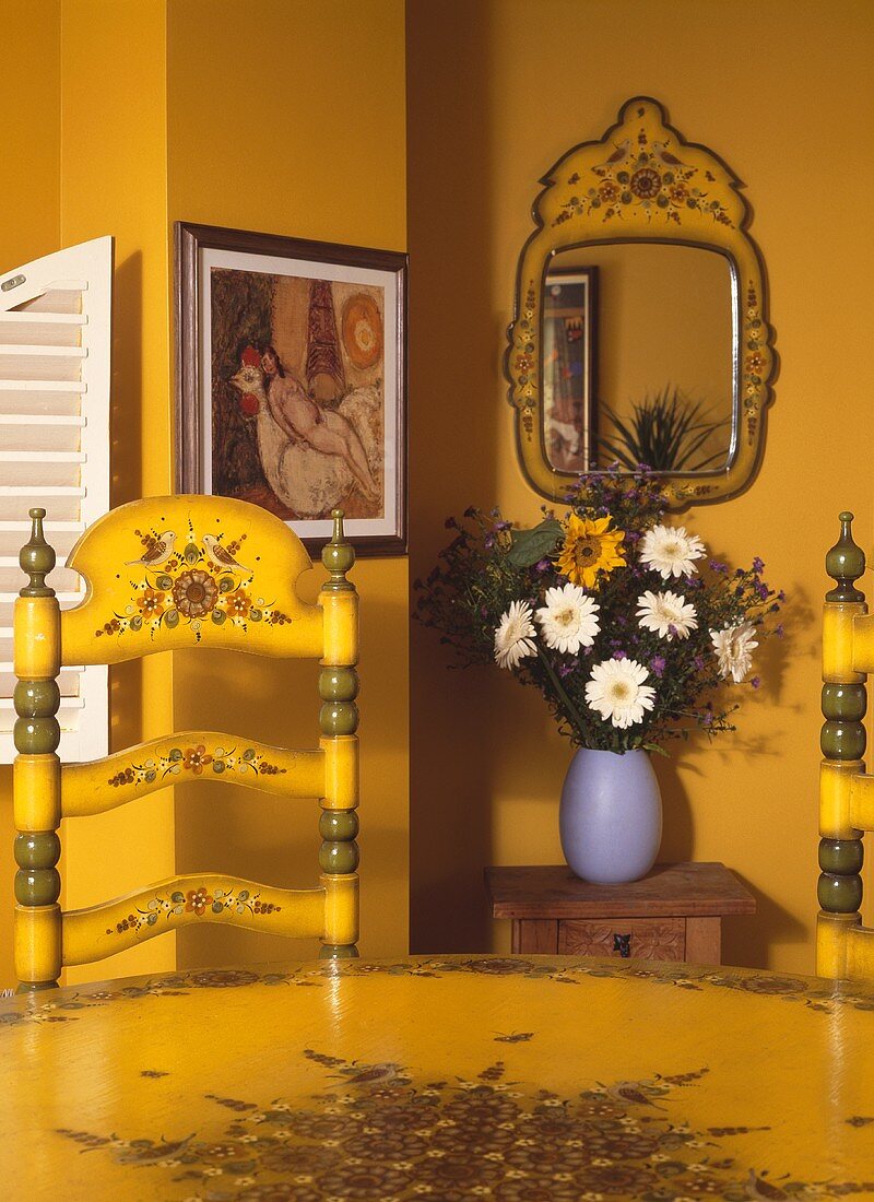 Esstisch mit Stuhl gelb lackiert im spanischen Stil vor gelber Wand