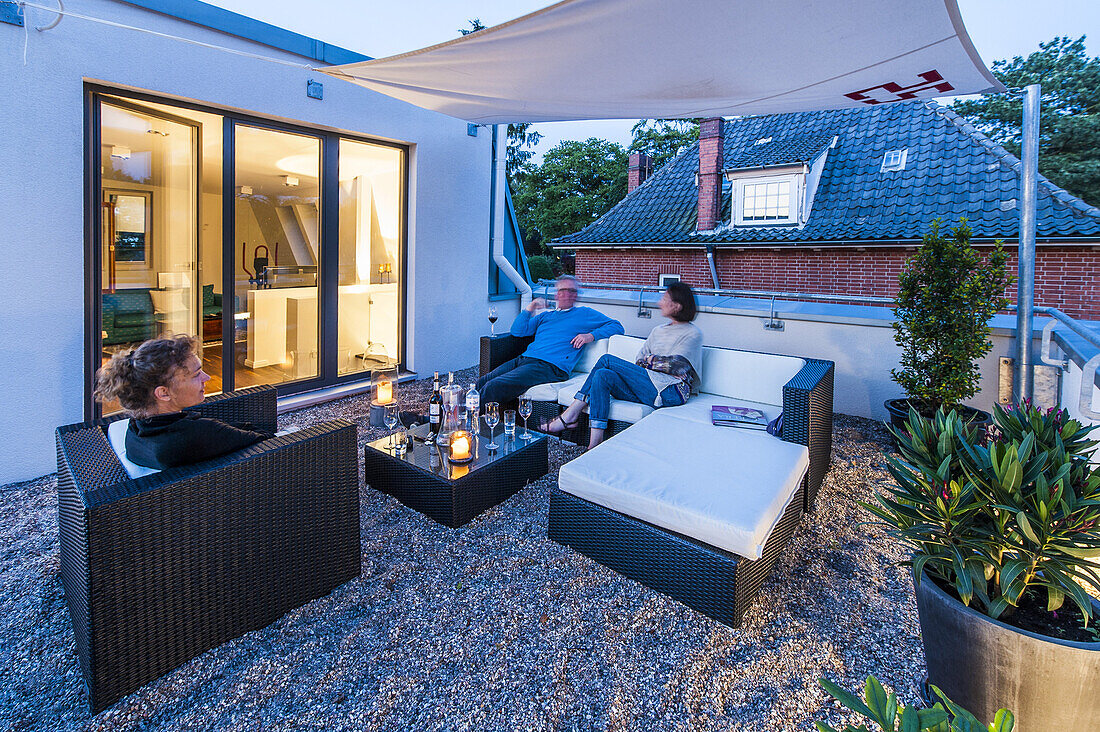 Leute sitzen auf einer Dachterrasse eines modernen Einfamilienhauses in Hamburg, Norddeutschland, Deutschland