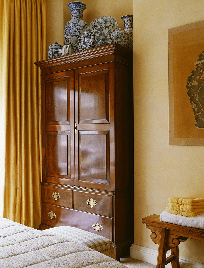 Antiker Kleiderschrank aus Eichenholz in einem traditionellen Schlafzimmer
