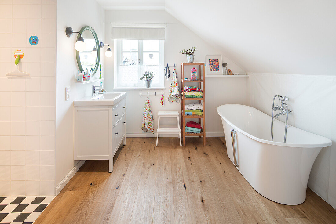 Badezimmer mit freistehender Badewanne im modernen nordischen Einfamilienhaus mit Dachschräge und Holzfußboden, Korbach, Hessen, Deutschland, Europa
