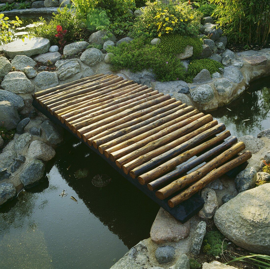 Eine kleine Brücke über einem schmalen Teich