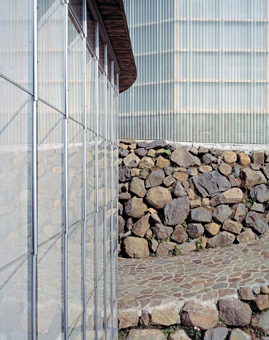 A corner of a newly built house with a natural stone wall