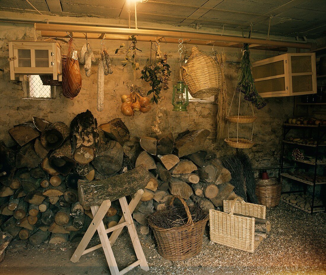 Eine Kammer mit Holzscheiten, Schinken, Salami, Zwiebeln, Kartoffeln, etc.